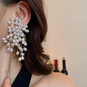 Detailed side view of elegant vintage pearl flower tassel dangling earrings on a model