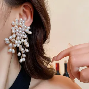 Detailed view of elegant flower-shaped pearl tassel earrings featuring sterling silver needles.