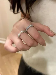 Elegante primo piano di un anello vintage in argento con perle e una fascia di zirconi brillanti