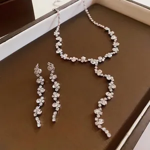 Elegant rhinestone tassel necklace and earrings jewelry set on brown display tray
