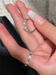 Primo piano di anello aperto vintage in argento ritorto con perle e pietre di zircone.