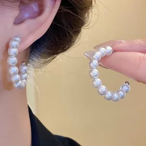 Detail view of elegant large pearl hoop earrings featuring a vintage and luxurious style