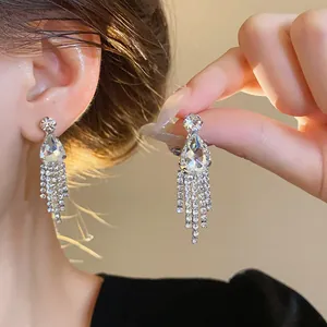 Elegant close-up of sparkling waterdrop tassel earrings featuring clear rhinestones.