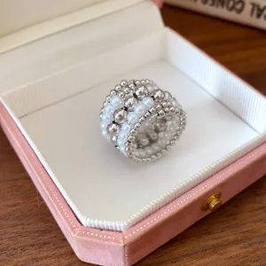 Anillo vintage multicapa con perlas blancas y cuentas de metal plateado en caja rosa