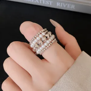 Primer plano detallado del elegante anillo multicapa con perlas y cuentas plateadas.