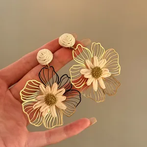 Handmade raffia and gold-tone metal flower dangle earrings in sweet vacation style