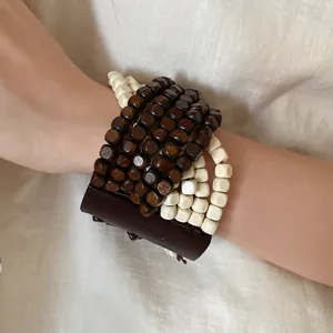Primo piano di un bracciale bohémien multistrato in legno con stile etnico al polso