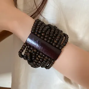 Primo piano di un braccialetto bohémien di perle di legno multistrato in stile etnico.