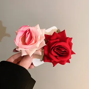 Close-up detail of elegant pink and red fabric rose flower hair clips for women styling