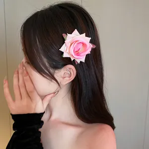Close-up of a pink rose flower hair clip worn by a model for a sweet, elegant look