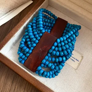 Dettaglio del bracciale multistrato in perle di legno boho, stile etnico vintage