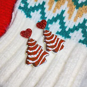 Detailed view of Christmas tree earrings with red glitter hearts on knitted background