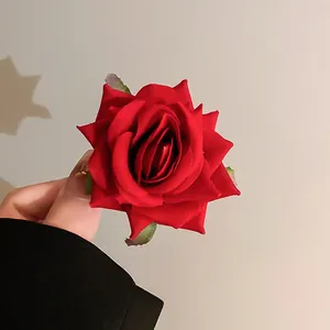 Detailed macro view of a vibrant red rose hair clip with realistic fabric petals