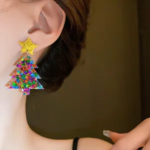 Macro view showing the glitter star and colorful tree details of the festive earring