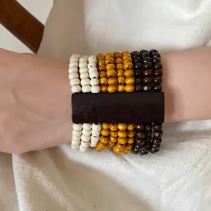 Primo piano di un bracciale bohémien multistrato con perle di legno indossato al polso