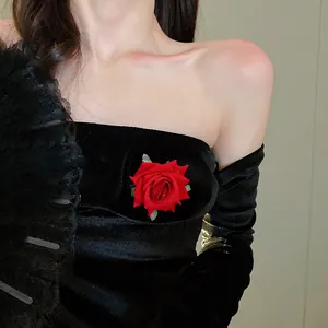 Elegant red rose flower hair clip detailed close-up on luxury black velvet fabric