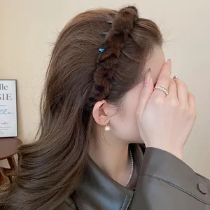 Detail view of brown plush leopard print headband on a model with pearl jewelry