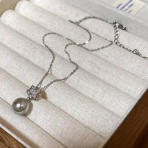 Close-up of a French vintage necklace featuring a grey pearl and crystal flower pendant.