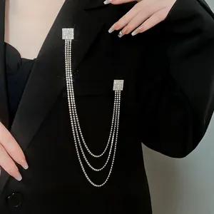 Elegante spilla con nappe a catena in argento e strass su un blazer nero lucido