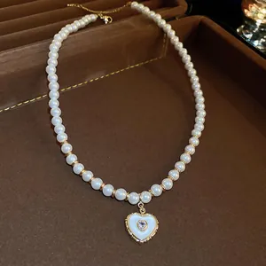 Vintage heart pendant pearl necklace with elegant gold finish presented in a brown jewelry box