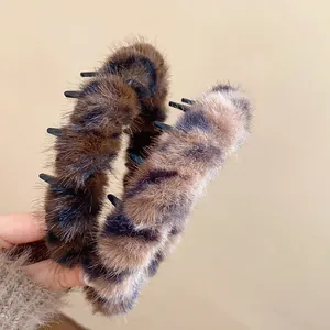 Detailed view of two vintage leopard print plush headbands with soft faux fur texture