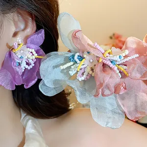 Detailed view of handmade chiffon flower earrings decorated with colorful glass beads