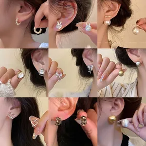 Detailed view of assorted minimalist pearl and cubic zirconia earring studs on models