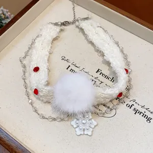 Close-up of white Christmas choker with fur ball, snowflake pendant and crystal pearls.