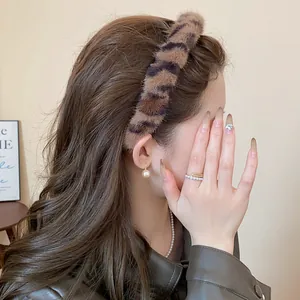 Leopard print plush headband shown on a model, featuring a voluminous high-top vintage style
