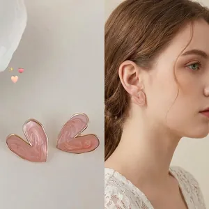 Close-up of pink marble heart stud earrings showing aesthetic design and model wearing effect