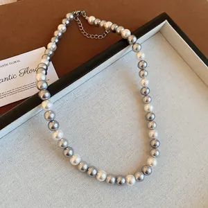 Close-up of a French vintage style gray and white pearl beaded necklace with a silver clasp