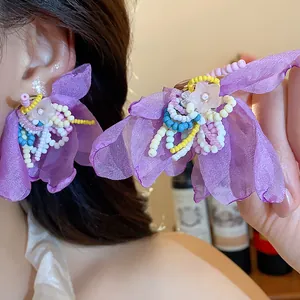 Detailed macro view of purple chiffon flower earrings with colorful glass beads