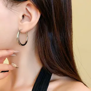 Close-up of elegant silver-colored round hoop earrings with a unique wavy pleated texture