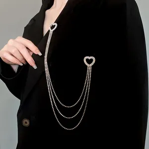 Vista dettagliata di un'elegante spilla a cuore con nappe in strass argento su un blazer nero