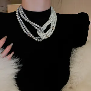 Detail of multi-strand retro French faux pearl necklace in grey and white colors.