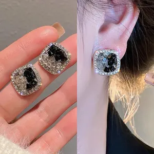 Detailed macro shot of elegant silver needle square zircon stud earrings for women