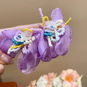 Close-up of purple chiffon flower earrings with colorful glass beaded details