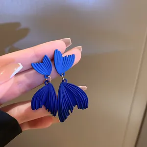 Orecchini a pendente a coda di sirena blu Klein opaco con perni in argento visti da vicino.