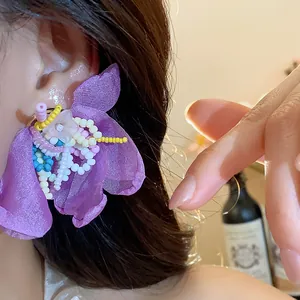 Detailed view of handmade purple chiffon flower earrings with colorful glass beaded centers