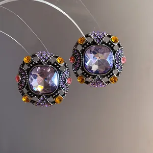 Close-up of vintage square stud earrings with purple crystals and colorful rhinestones.
