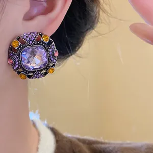 Detail shot of a vintage court-style stud earring featuring a large purple square gemstone