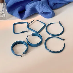 Vue détaillée de créoles élégantes peintes en bleu Klein de diverses formes