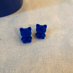 Macro dei piccoli orecchini a gatto blu floccati con dettagli morbidi