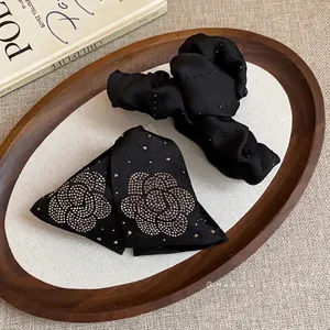 Elegant black fabric hair claw clip and bow set with rhinestone camellia flower design