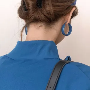 Créoles bleu Klein mat portées par un mannequin avec chignon