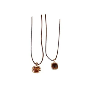 Vintage Tiger's Eye pendant necklaces with brown cords in round and square shapes.