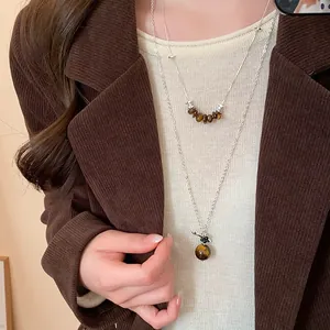 Close-up of vintage French style necklace with round tiger's eye stone pendant