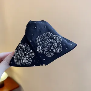 Close-up detail of black fabric hair claw clip with elegant silver rhinestone flower pattern