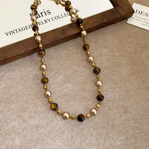 Detailed view of a vintage brown tiger eye necklace with pearls and gold-tone spacers