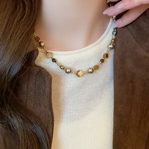Detailed view of vintage brown tiger eye beaded necklace with amber tones on neck